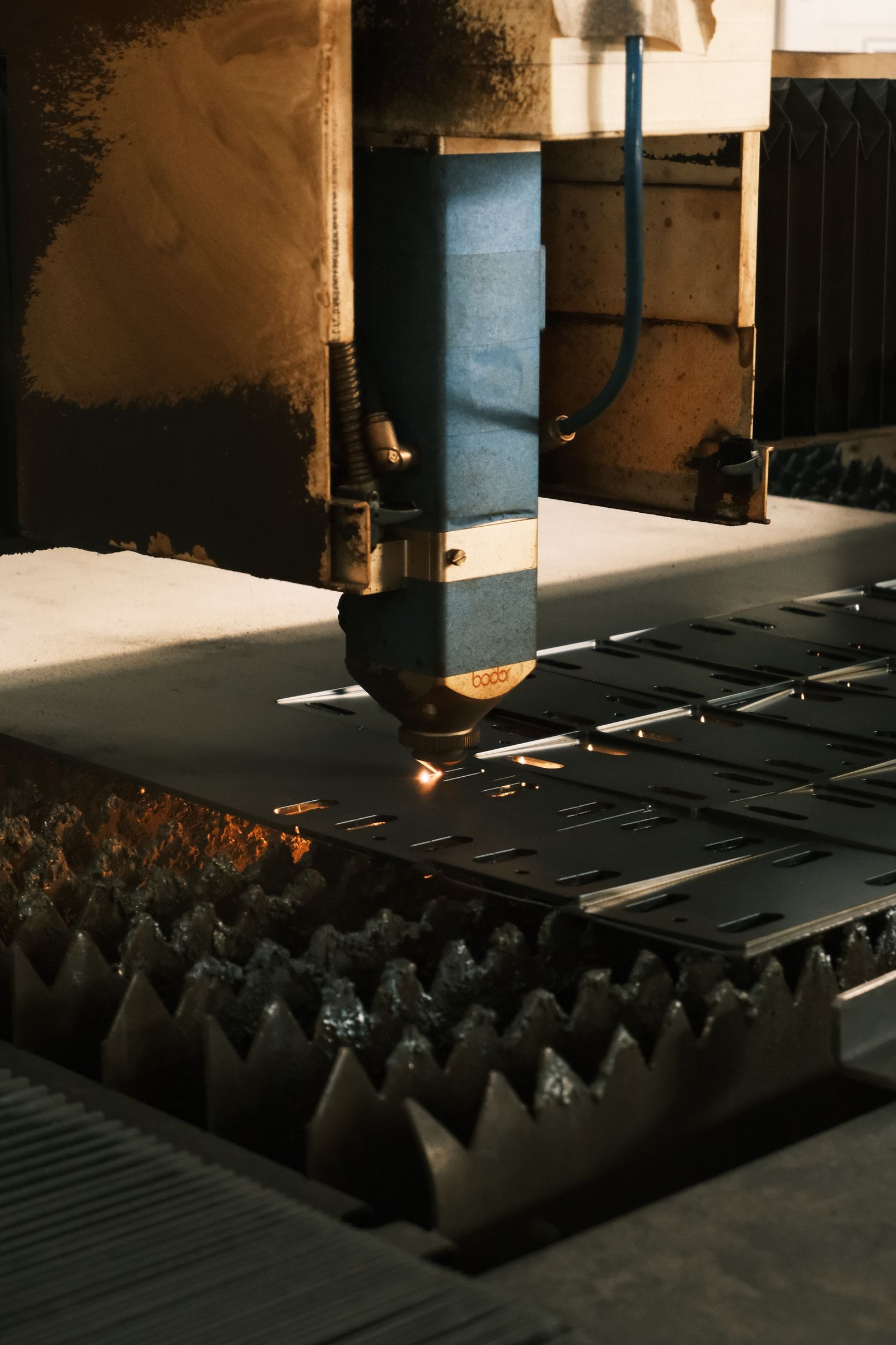 A laser cutting head focused on a metal surface